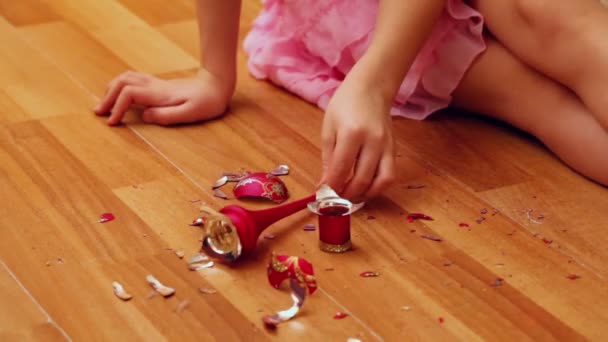 Κορίτσι παίρνει θραύσματα από σπασμένο παιχνίδι — Αρχείο Βίντεο