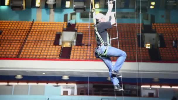 Worker climbs down by rope ladder — Stock Video