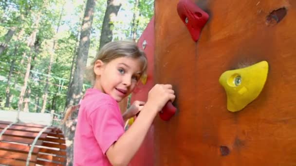 Mała dziewczynka wkrada się na ścianie wisiorek — Wideo stockowe