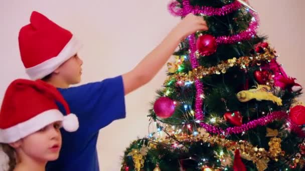 Dos niños con gorras de santa — Vídeos de Stock