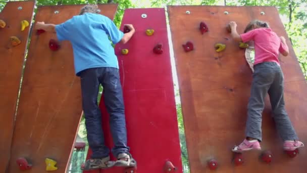 Duas crianças rastejam na parede pingente — Vídeo de Stock