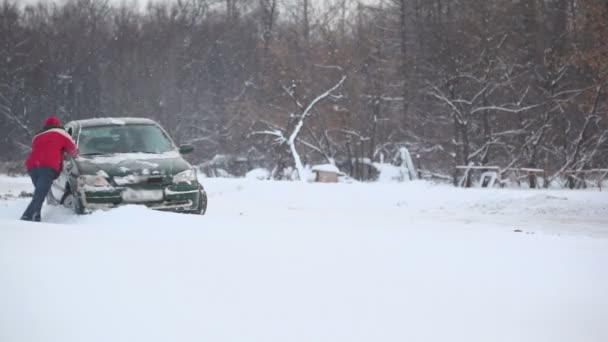 Мужчина и женщина пытаются выпустить автомобиль — стоковое видео