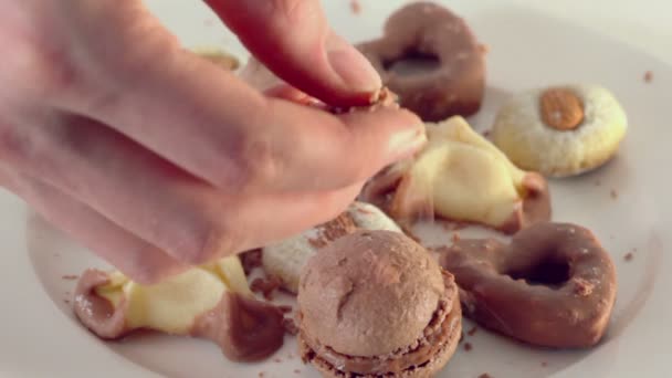 Hand streut Schokoladenbrösel auf Kekse — Stockvideo