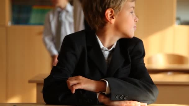 Niño sentado en el escritorio en el aula — Vídeos de Stock