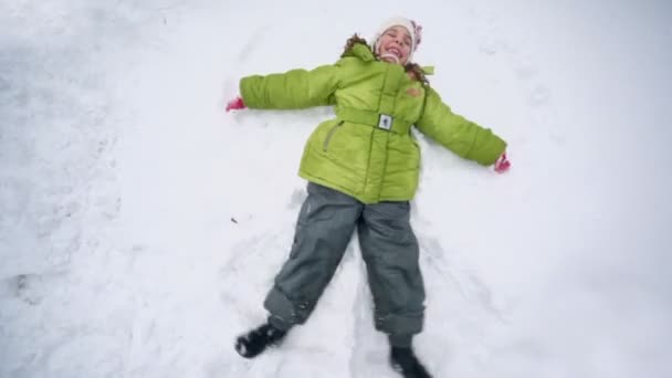 Little girl lies on snow — Stock Video