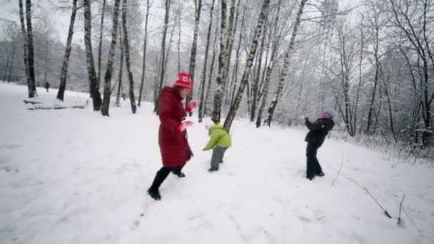 女人和她的孩子们一起玩雪球 — 图库视频影像