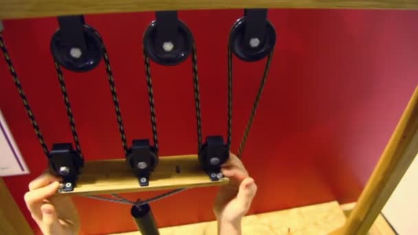 Рука тянет веревку с шкивами и цилиндром — стоковое видео