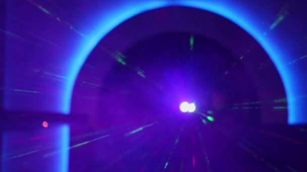 El láser emite rayos bajo el arco azul — Vídeo de stock