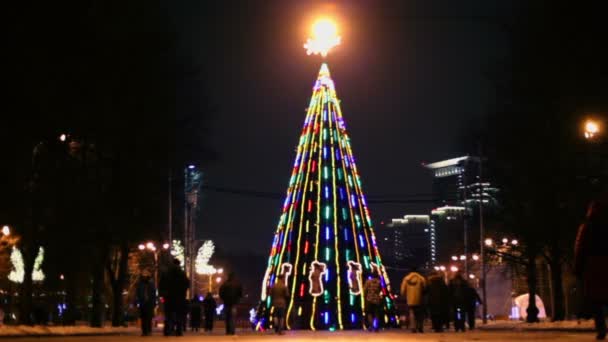 As pessoas caminham perto da árvore de Natal — Vídeo de Stock