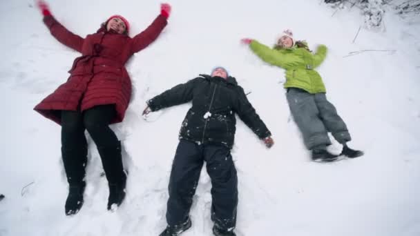 Мать с детьми лежала на снегу — стоковое видео