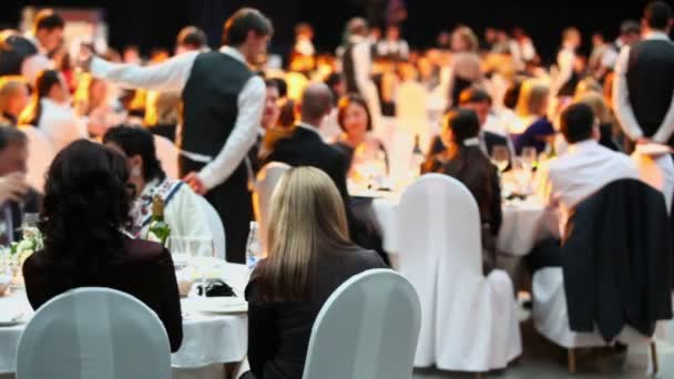 Mensen zitten aan tafels tijdens de ceremonie — Stockvideo