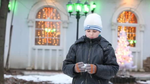 Niedlicher kleiner Junge, der mit Schneeball spielt — Stockvideo