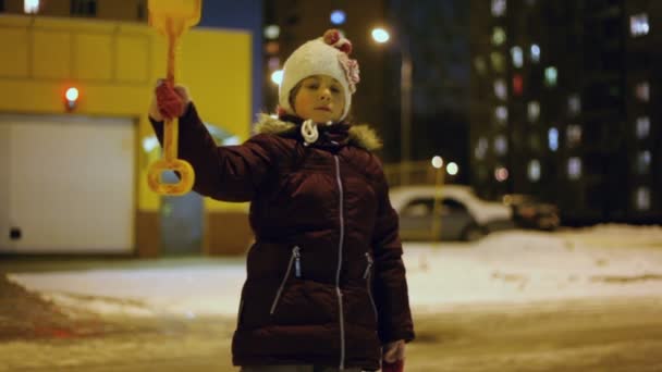 Маленькая девочка держит игрушечную лопату — стоковое видео