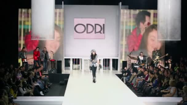 Model in winter clothes walks by podium — Stock Video