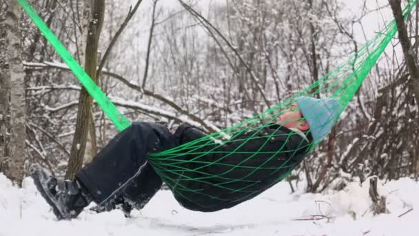 Jonge jongen in warme kleren op hangmat — Stockvideo