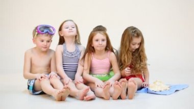 Dört çocuk üzerinde plaj havlusu siting