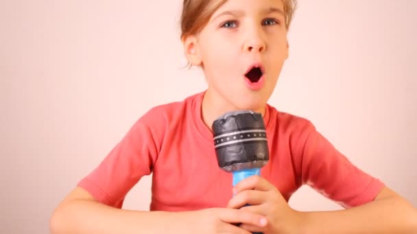 Милая девушка разговаривает по микрофонной игрушке — стоковое видео