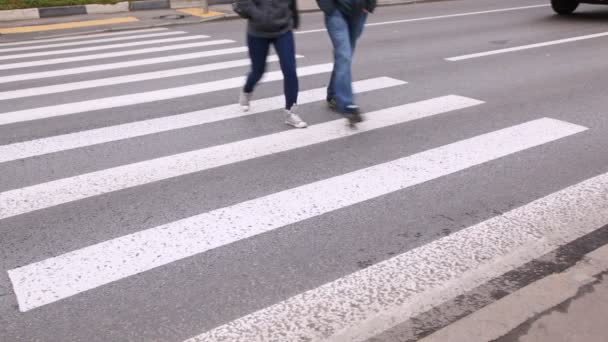 Três pessoas atravessando estrada na encruzilhada — Vídeo de Stock