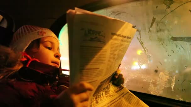 Mädchen im Auto liest Zeitung — Stockvideo
