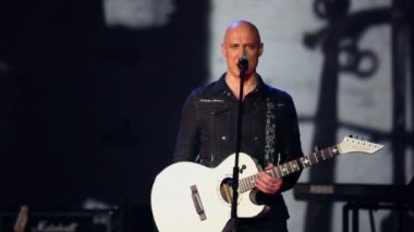 Denis Maidanov gitar ile şarkı söylüyor