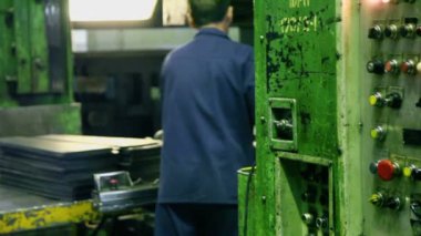 İşçinin basın makine altındaki bileşenin koyar