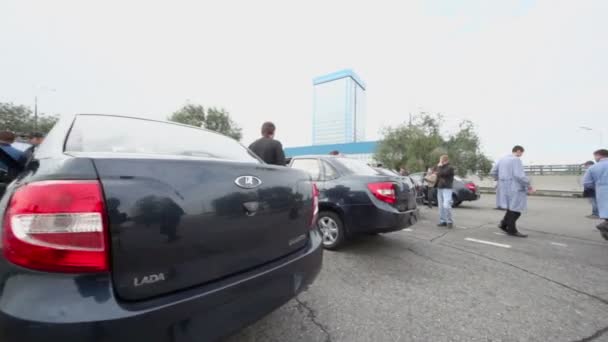 Люди наблюдают за автомобилями на тест-драйве — стоковое видео