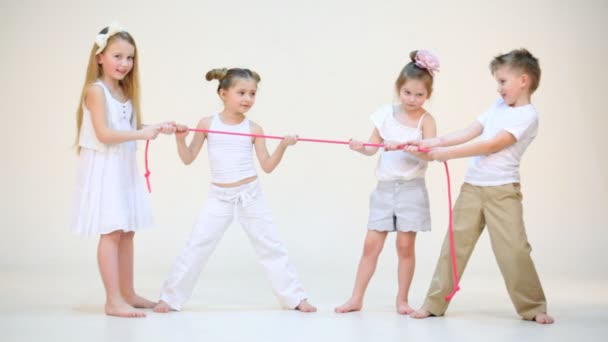 Четыре очаровательных ребенка с розовой веревкой — стоковое видео