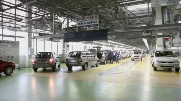 La gente trabaja en el transportador con coches nuevos — Vídeos de Stock