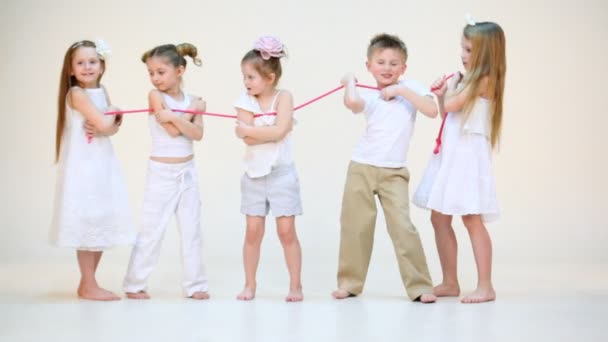 Vijf gelukkige kinderen met roze touw — Stockvideo