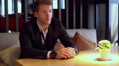 Sarışın adam restoranda oturur