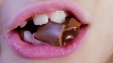 Çocukça ağız çikolata şeker çiğniyor