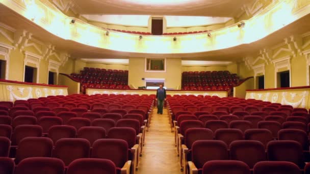 Female goes between chair rows — Stock Video