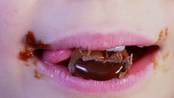 Boca infantil mastiga chocolate doce — Vídeo de Stock