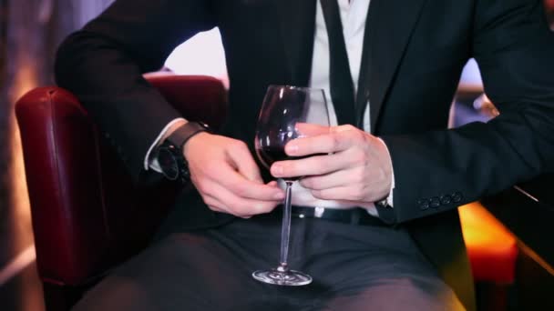 Мужчина держит бокал красного вина — стоковое видео