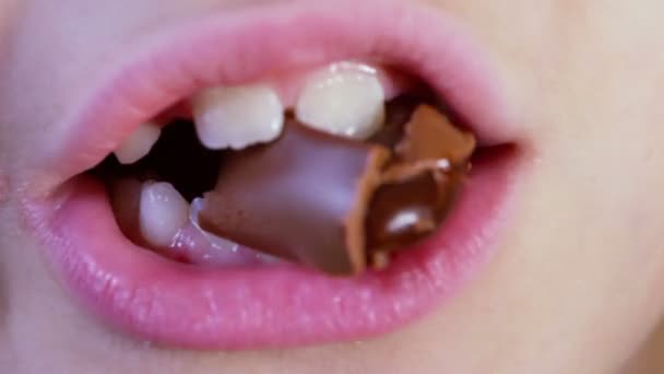 Barnslig munnen tuggar choklad godis — Stockvideo