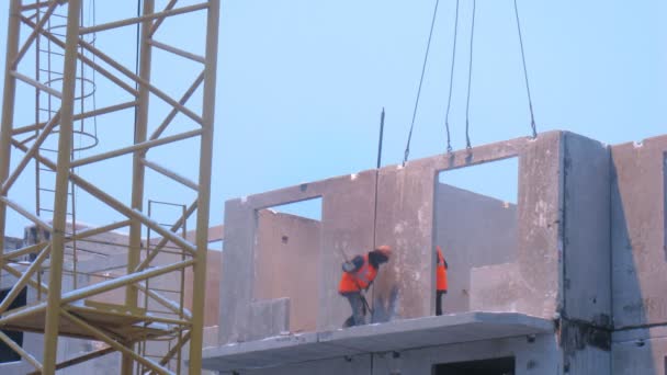 Trabajadores asegurando panel de bloque en el edificio — Vídeo de stock