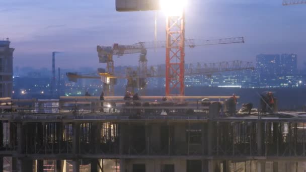 Grúas y trabajadores en la parte superior del edificio — Vídeo de stock