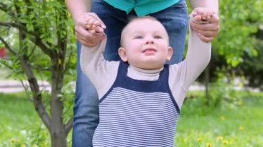 Anne küçük oğlu ellerini tutar