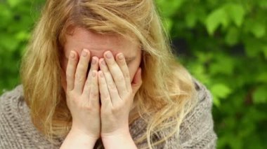 Düşünceli kadın yüzünü kapatır