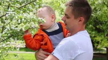 Adam gülümsüyor ve oğlu tutar