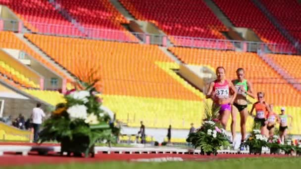 Sportswomen run by track during race — Stock Video