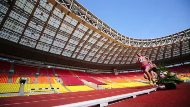 Atletas femeninas corren por pista de estadio — Vídeos de Stock