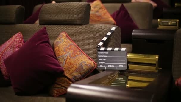 Movie clapper board on lounge with cushions — Stock Video