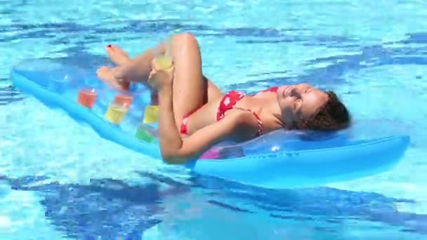 Vrouw zwemt in het zwembad op lucht matras — Stockvideo