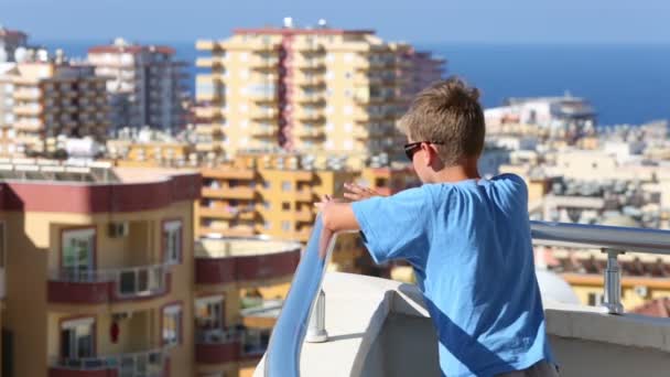 Kleiner Junge steht auf Balkon — Stockvideo