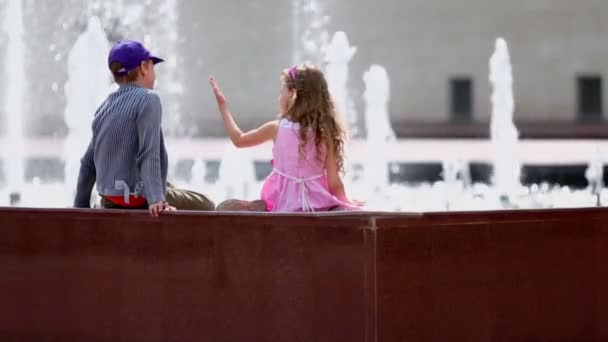 Chłopiec i dziewczynka na granicy fontanna — Wideo stockowe