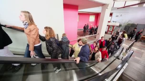 Los niños viajan en escaleras mecánicas cerca de la entrada — Vídeos de Stock