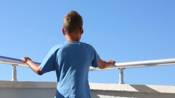 Kleine jongen staande op balkon — Stockvideo