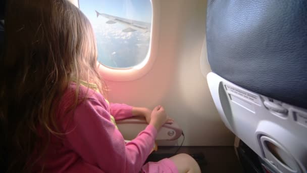 Malá holčička vypadá z okna v letadle — Stock video