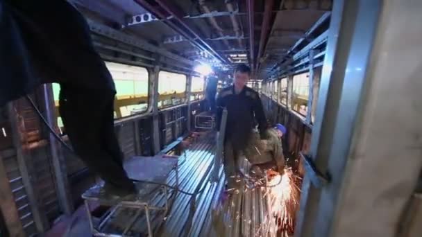 Arbeiders dragen frame en weld — Stockvideo